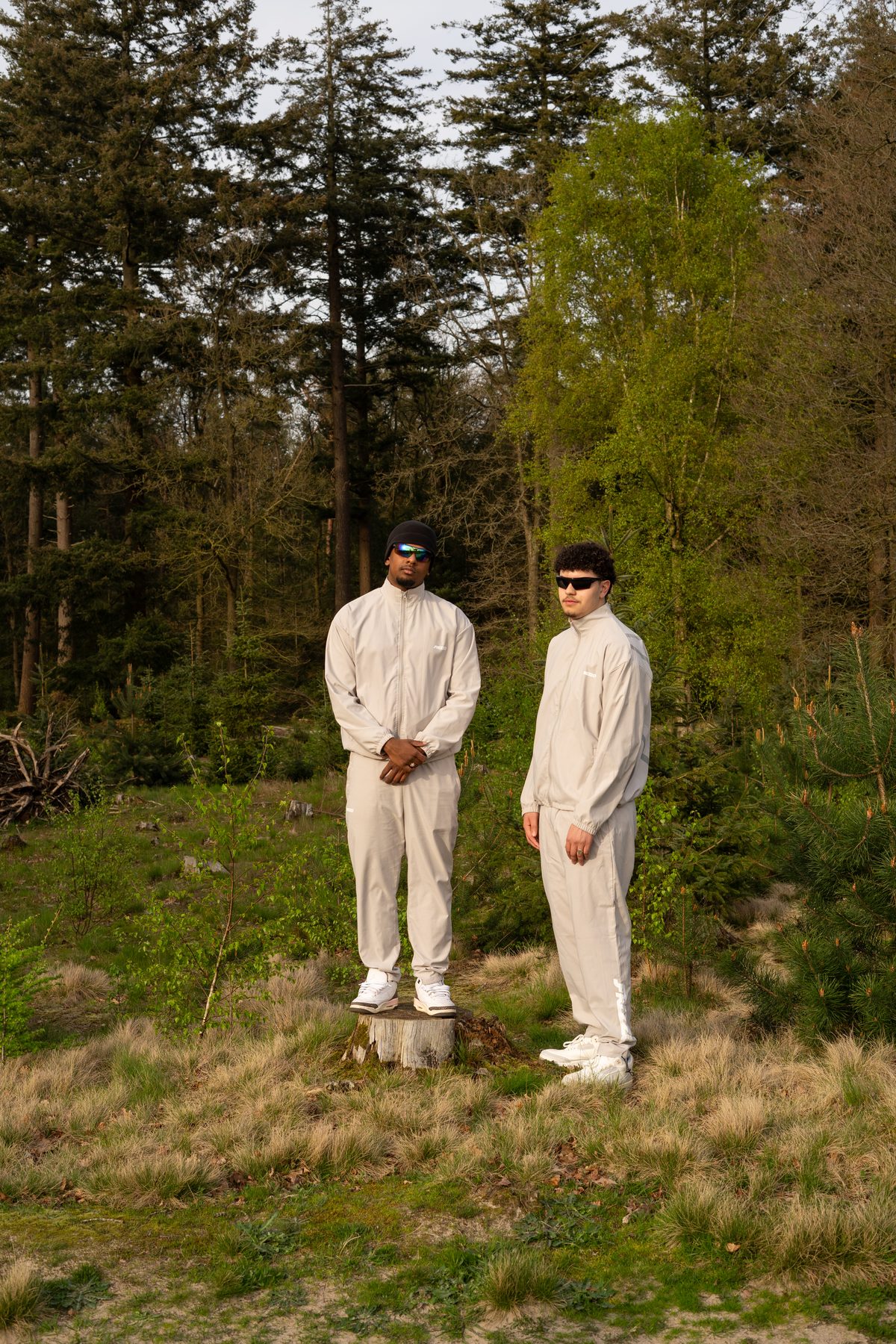 Zwei Models im Trainingsanzug vor Kiefern