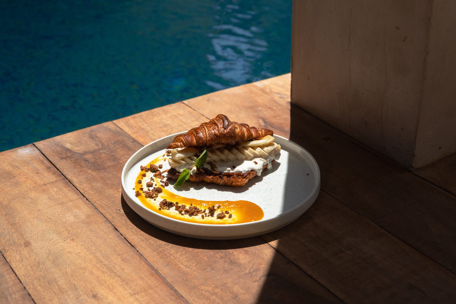 Croissant auf einem Holztisch am Pool