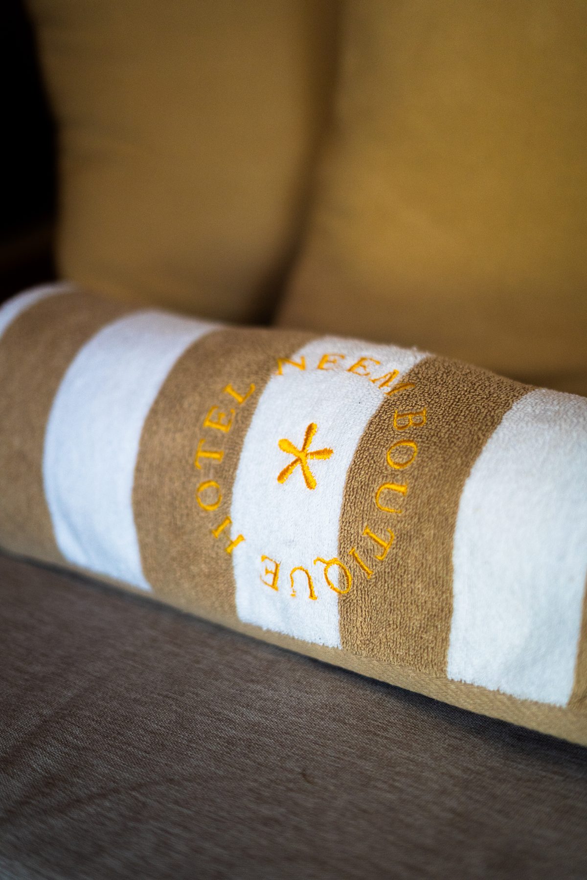 Gestreifte Handtuchrolle mit gesticktem Hotelnamen